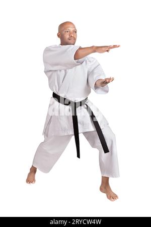 african american karate man in a kumite stance, exercising his kata, in white kimono uniform with belt Stock Photo