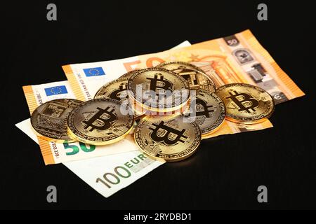 Gold bitcoin physical coins on paper Euro banknote Stock Photo