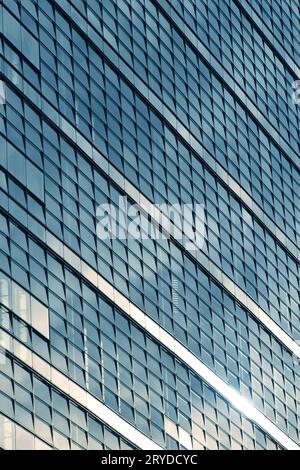 closeup to a modern blue skyscraper windows reflection white clouds and ...
