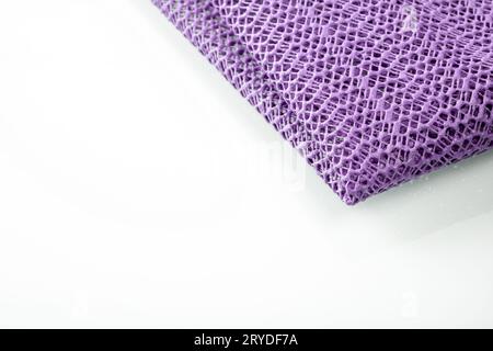 Corner of a lavender colored kitchen napkin on a white background, space for text. Stock Photo