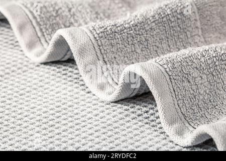Soft terry towel folded in waves on a gray background close-up. Stock Photo