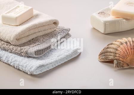 Bathroom accessories. Stack of towels, soap and shell on the dressing table. Stock Photo