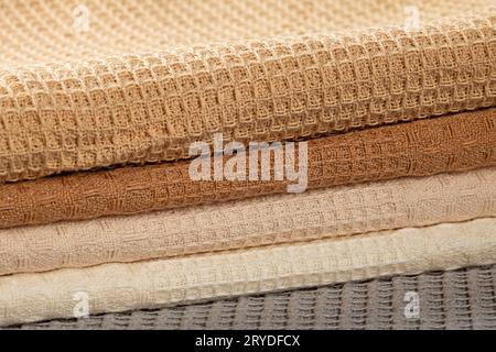 Stack of beige,gray and cream colored waffle kitchen towels folded into folds close-up. Stock Photo