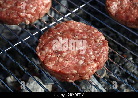 Raw beef burger for hamburger on barbecue grill Stock Photo