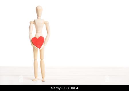 Wooden mannequin holding a red heart Stock Photo