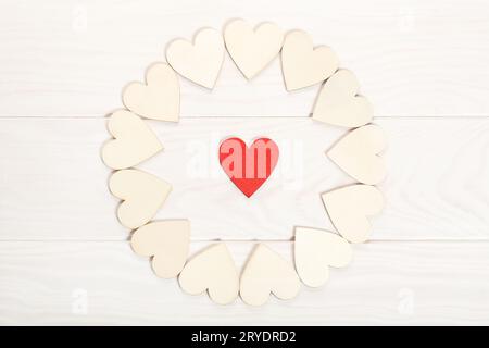 Red wooden heart surrounded by other hearts on wooden background Stock Photo