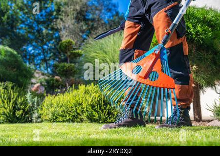 Garden Worker with Plastic Modern Rake in His Hands Close Up. Stock Photo