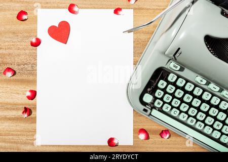 Love letter. Desk with blank paper, retro typewriter and red heart Stock Photo