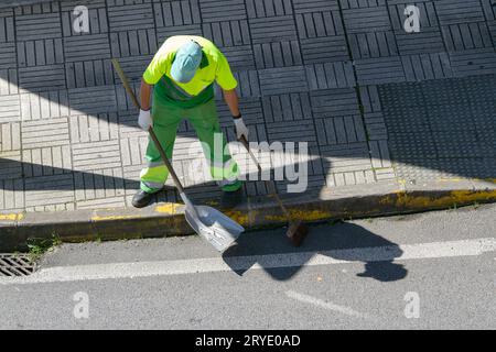 Street sweeper with broom and shovel working on city Stock Photo