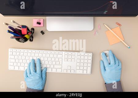 Hands with protective glove typing on keyboard computer Stock Photo