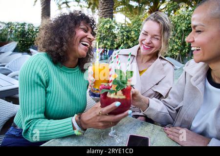 Portrait three happy middle aged multiracial women smiling outdoor. Group cheerful adult female. Stock Photo