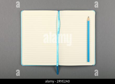 Open blue notebook with pencil over grey Stock Photo