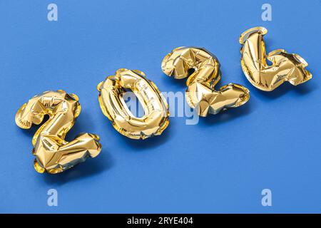 Figure 2024 made of golden foil balloons on color background Stock Photo