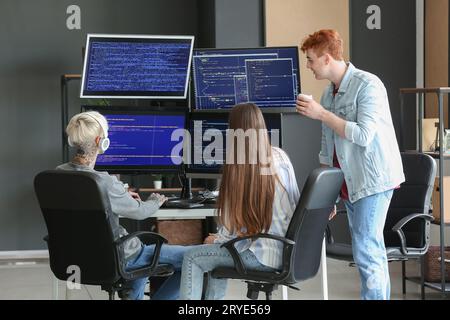 Young programmers with coffee working in office, back view Stock Photo