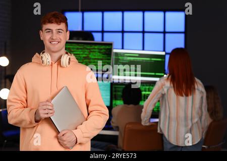Male programmer with laptop in office at night Stock Photo