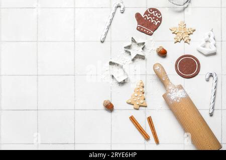 Christmas gingerbread cookies, baking molds and rolling pin on white tile background Stock Photo