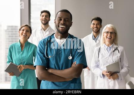 Happy African American surgeon man standing in front of colleagues Stock Photo
