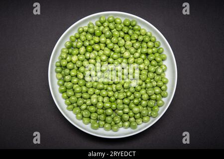 Top view of a plate with fresh Green pea isolated on black background Stock Photo