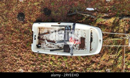 Aerial drone shot of laughing woman sitting in boat on land Stock Photo