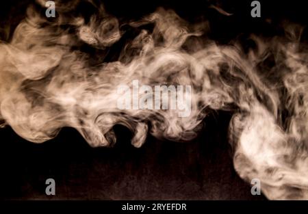Dense Fluffy Puffs of White Smoke and Fog on Black Background, Abstract Smoke Clouds, All Movement Blurred, intention out of focus, and high low expos Stock Photo