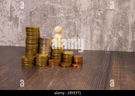 Miniature people toy figure photography. Income and salary growth. A men worker labor sitting above staircase coin pile. Image photo Stock Photo