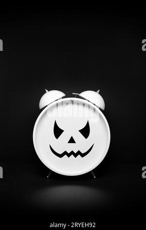 Retro Clock with scary face on dark background Stock Photo