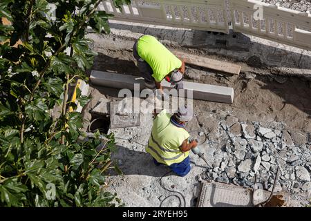 Construction workers working on sidewalk Stock Photo