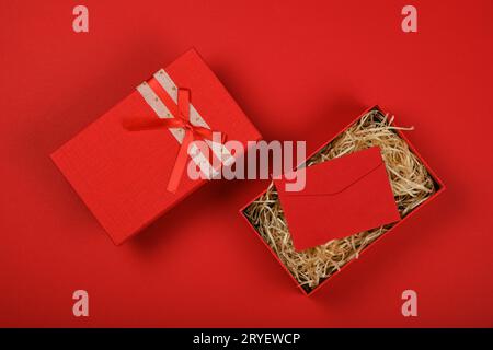 Open red gift box with ribbon bow and envelope Stock Photo