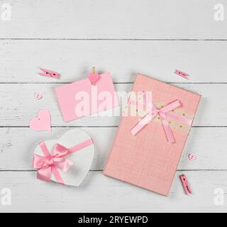 Pink gift boxes and paper note on white table Stock Photo