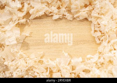 Carpentry or woodworking background with copy space. Border frame of wood shavings on wood table Stock Photo