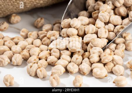 Close up of Chickpeas on scoop on White marble Background. Cicer arietinum Stock Photo