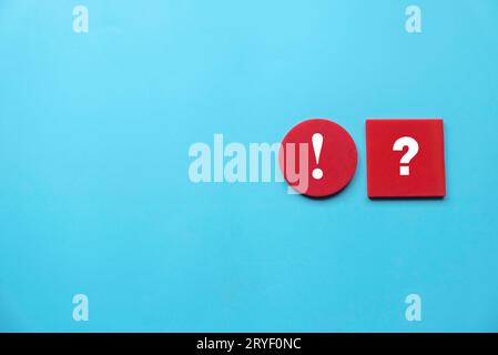 Concept of uncertainty, urgency, importance, inquiry, faq, questions and answers. Exclamation mark and question mark symbol on red wooden square and c Stock Photo