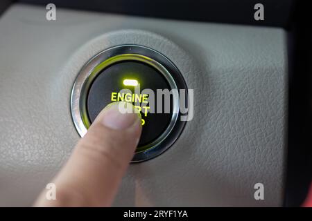 Man finger on pushing a start ignition button switch in the modern luxury car Stock Photo