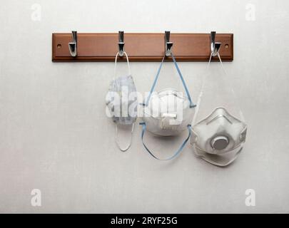 Several respirator masks hanging on clothes rack Stock Photo