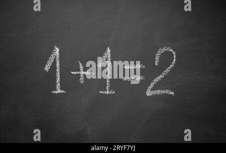 One plus one equals two hand written on chalkboard. Math simple equation Stock Photo