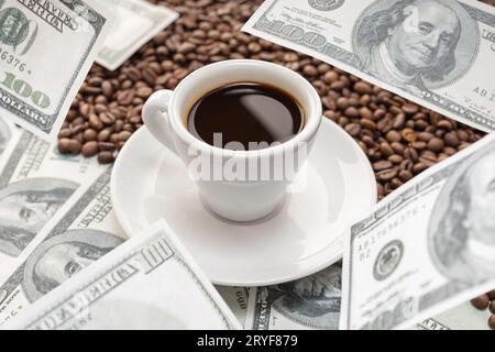 Cup of coffee on Coffee beans and dollar banknotes flying around it. Rising coffee prices concept Stock Photo