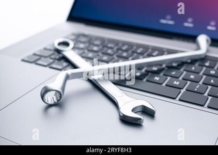Computer fixing, service or maintenance concept background. Working tools on modern laptop computer Stock Photo