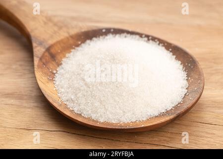 Sugar In Wooden Spoon on wooden table. Close up Stock Photo