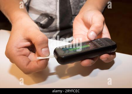 Blood sugar level measurement with a blood glucose meter Stock Photo