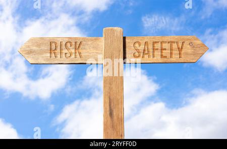 Risk or Safety concept. Wooden signpost with message on sky background Stock Photo