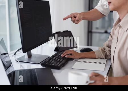 Two developer programmer discussing to checking code on monitor about programming to developing web. Stock Photo