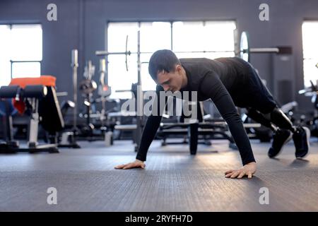 serious ambitious young sportsman with artificial legs doing push ups. full length side view shot. copy space, wellness, willpower. motivation Stock Photo
