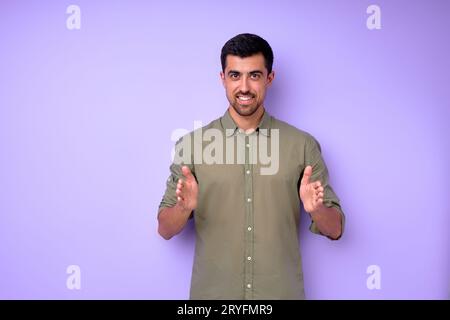 Young deaf mute man saying walls using sign language on blue background, close up portrait isolated, building house concept Stock Photo