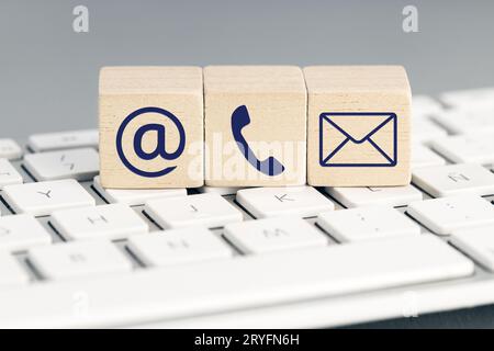 Contact us icons on wooden blocks on computer keyboard Stock Photo