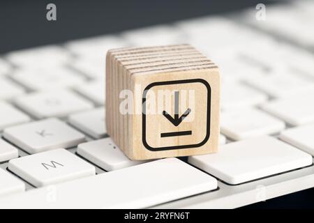 Download icon on wooden block on computer keyboard. Downloading data storage Stock Photo