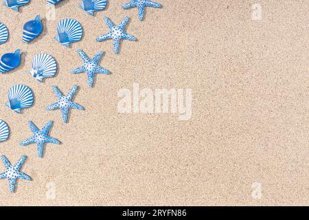 Summer background with blue seashell pattern on beach sand background. Copy space. Top view Stock Photo