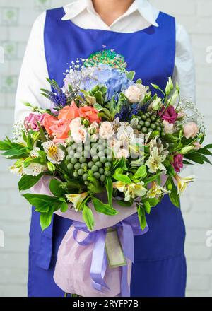 Woman holding a beautiful bouquet with roses, lisianthus, alstroemeria, and hortensia Stock Photo