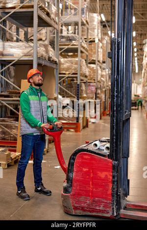 engineer staff male warehouse worker in hard hat working. in logistics center warehouse factory. Portrait of happy smiling caucasian young worker posi Stock Photo