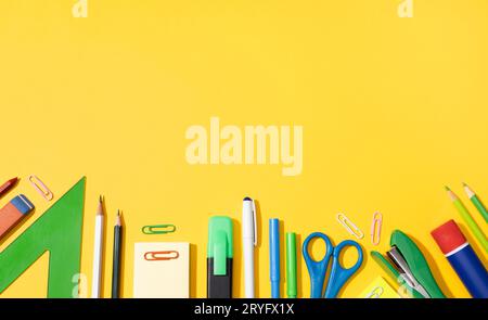 Back to school background with copy space. Variety of Office and school supplies on yellow background Stock Photo