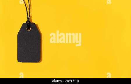 Blank black tag isolated on yellow background with copy space. Template Mock up Stock Photo